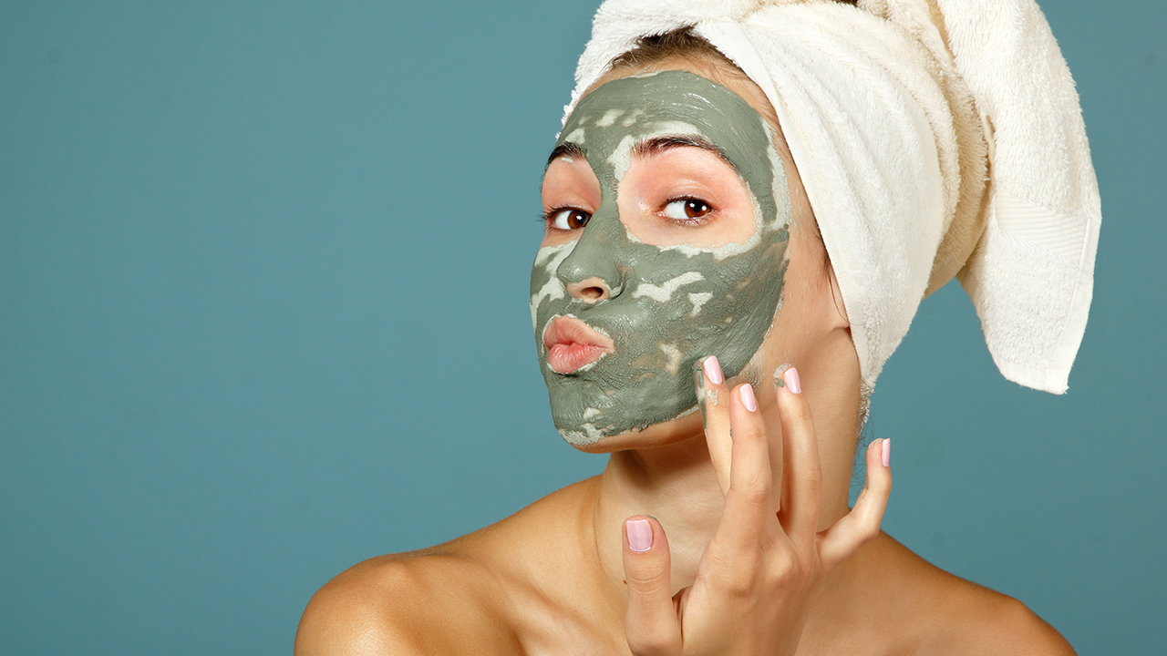 Mujer con mascarilla facial de arcilla